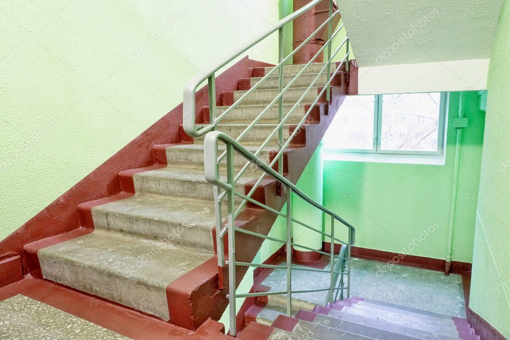 Addetta alle pulizie che pulisce le scale di un condominio